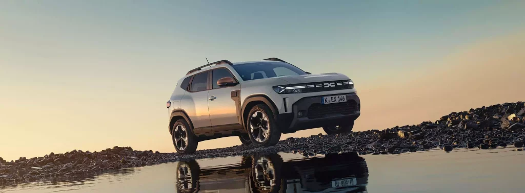 Beiger Dacia Duster vor weiter Landschaft